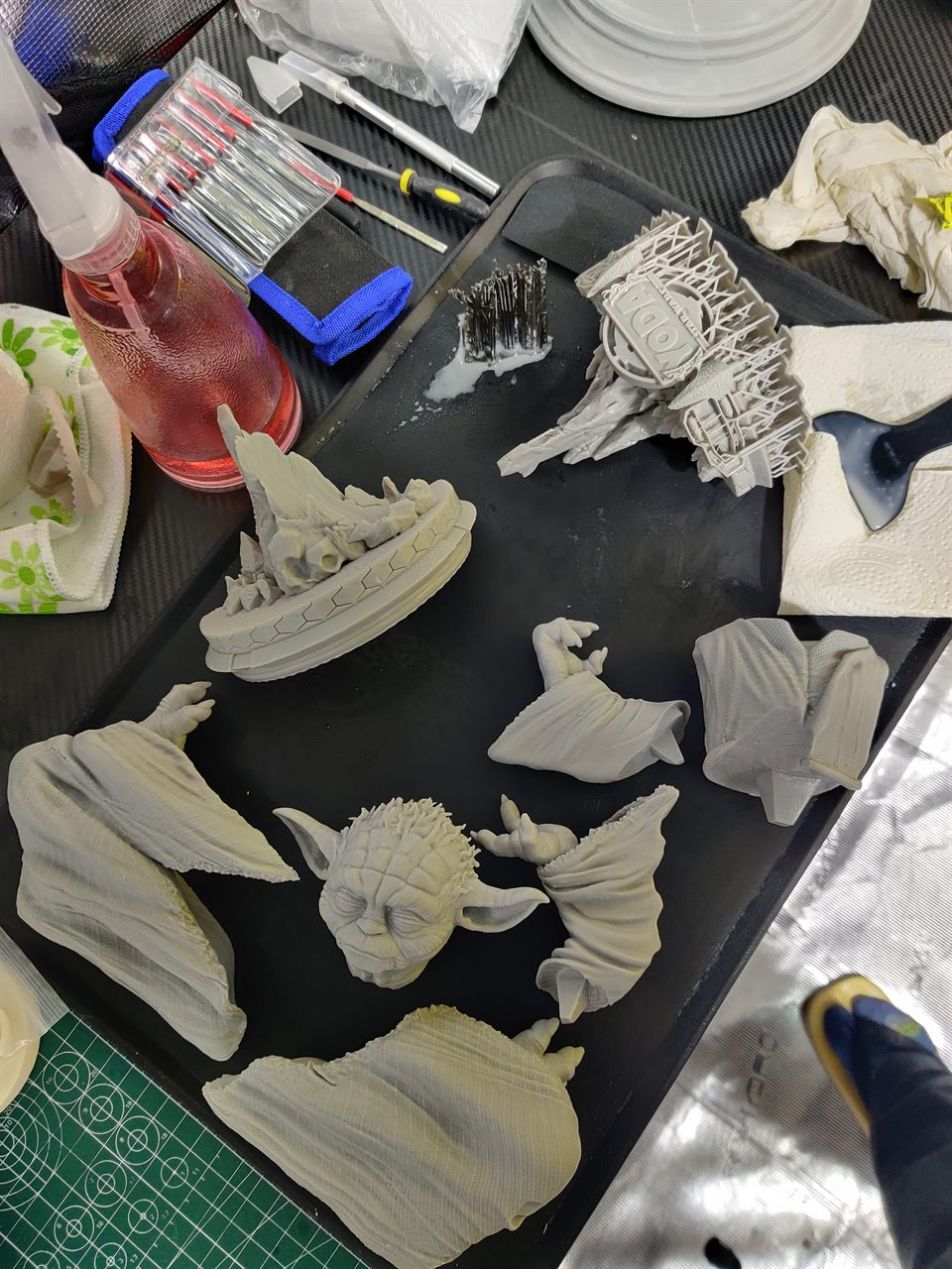 Pièces d'une figurine en résine posées sur un plateau avant assemblage