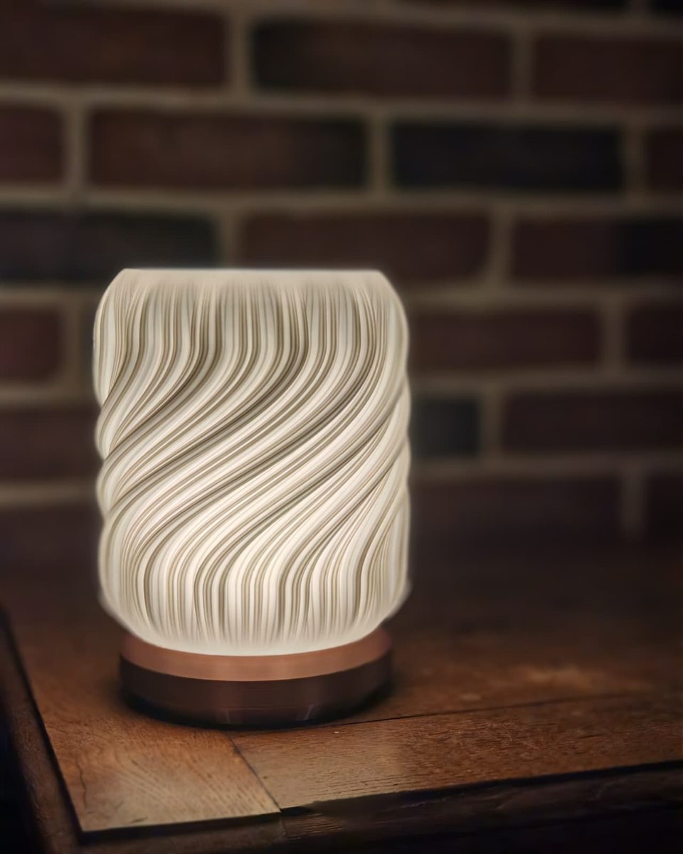 Lampe imprimée en 3D, abat-jour blanc torsadé allumé sur un socle cuivré